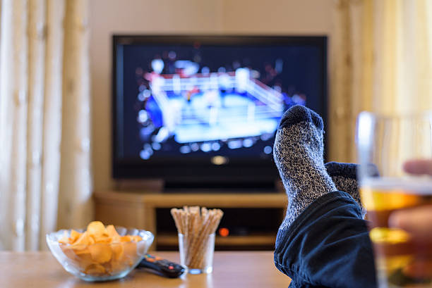 istock Television, TV watching (boxing match) with feet on table 516250506