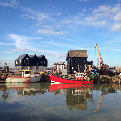 Whitstable harbour, Kent, Uk with fisherman's huts and fishing boats. Mobilestock.