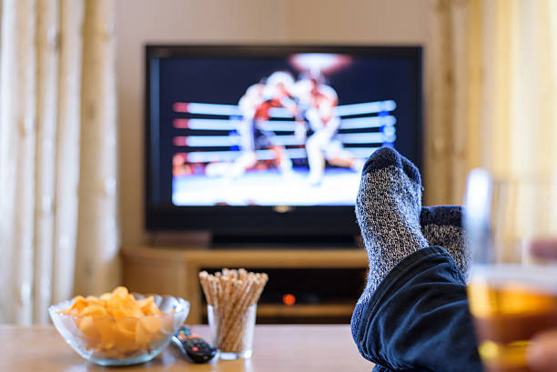 istock Television, TV watching (boxing match) with feet on table 516250864