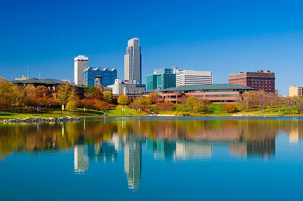 Omaha downtown skyline during Autumn, with a lake at the Heartland of America Park in the foreground