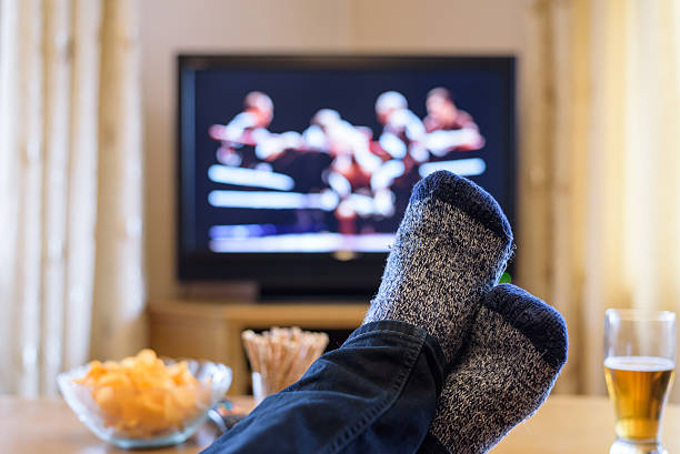 istock Television, TV watching (boxing match) with feet on table 516251084