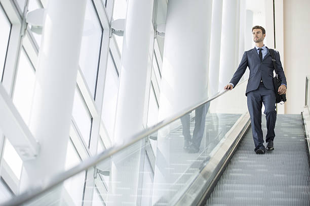 istock Businessman at the airport going down the escalator 516251279