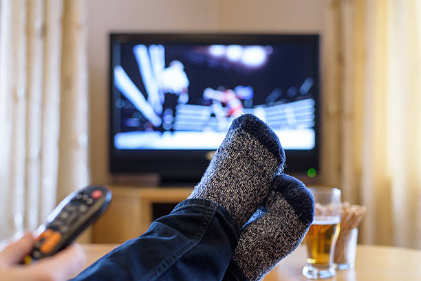 istock Television, TV watching (boxing match) with feet on table 516251336