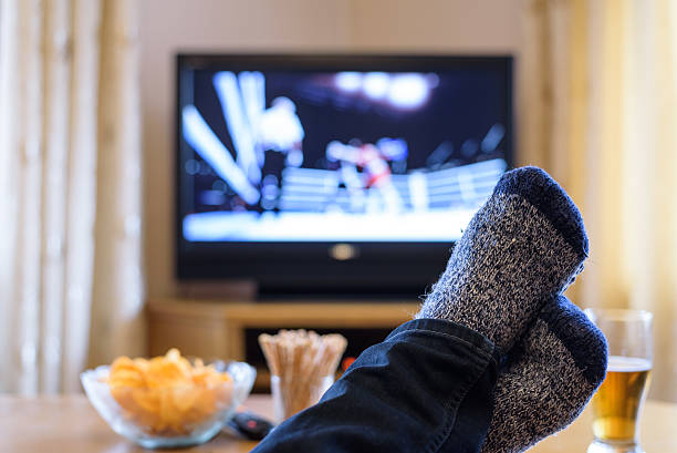 istock Television, TV watching (boxing match) with feet on table 516251496
