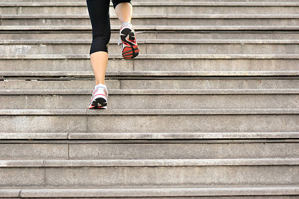 Runner athlete legs running on stairs. woman fitness jogging workout wellness concept.