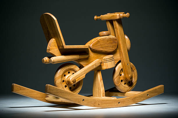Wooden rocking toy motorbike on dark background