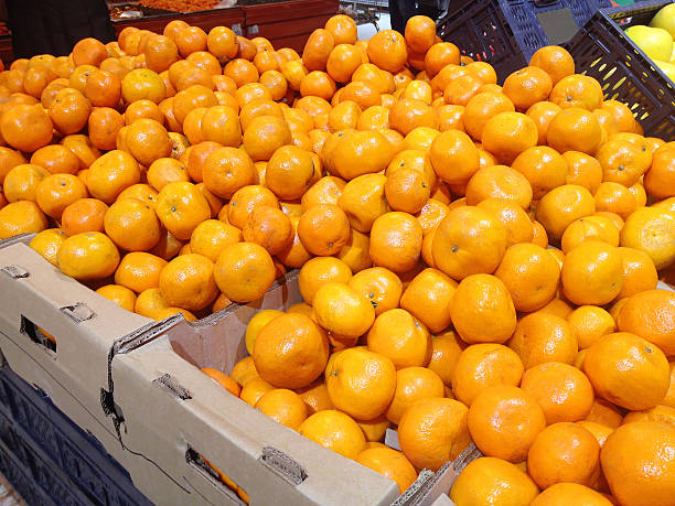 istock Fruits mandarins lying boxes in supermarket 516253410