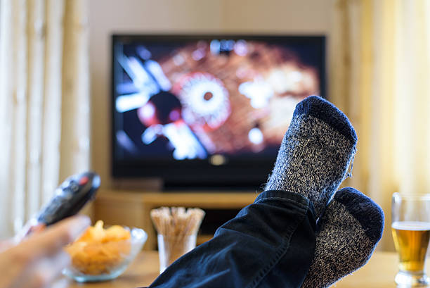 istock Television, TV watching (basketball game) with feet on table 516253760