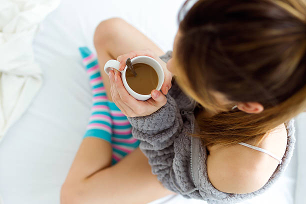 istock Beautiful young woman drinking coffee on bed. 516254104
