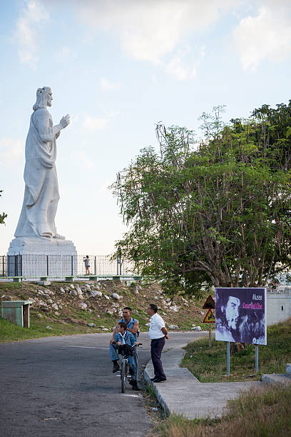 Havana, Cuba - December 17, 2014: Cubans stand outside the entrance to La Cabana de Che Guevara, a museum located at a home where he once lived, in Havana, Cuba. On the left is the Christ of Havana sculpture (Cristo de La Habana).