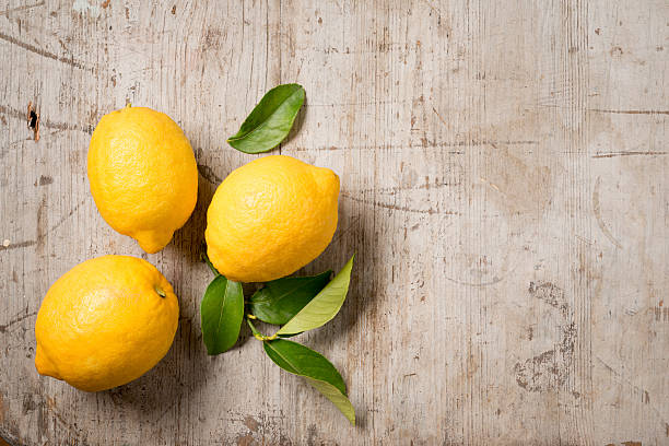 istock Three lemons and leaves on wood 516254246