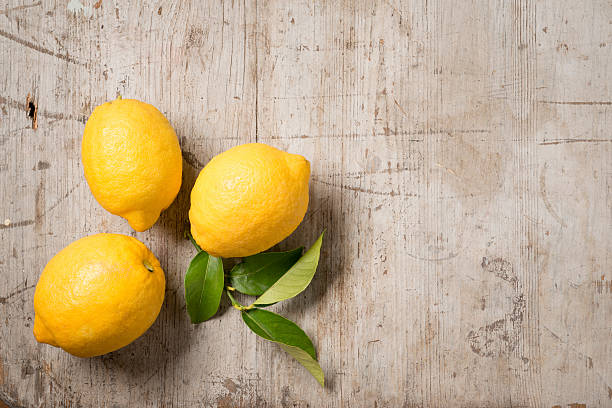 istock Three lemons and leaves on wood 516254390
