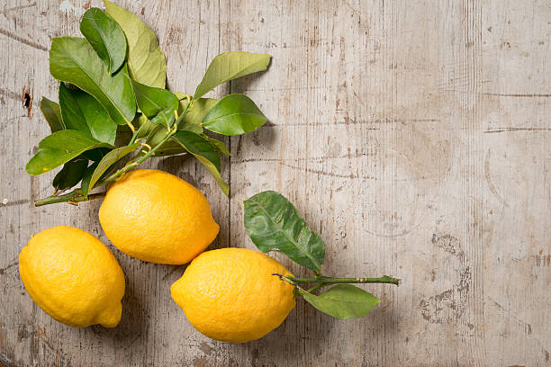 istock Three lemons and leaves on wood 516254498