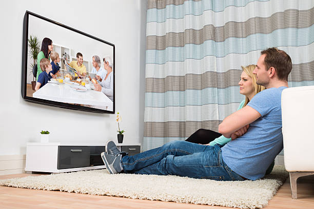 istock Couple Watching Television In Living Room 516254506