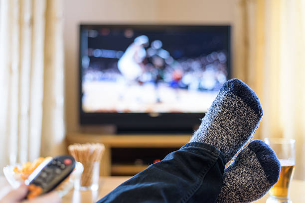 istock Television, TV watching (basketball game) with feet on table 516254704