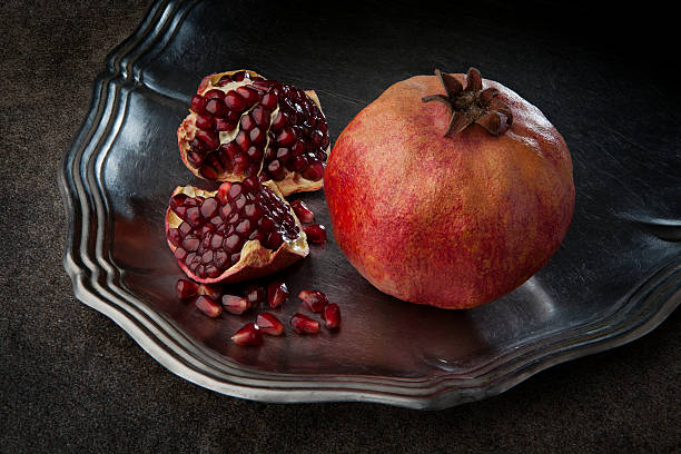 istock Pomegranate with seeds on a dark background 516255880