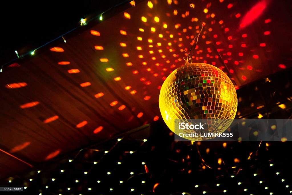 Mirror disco ball with light reflection on the ceiling Mirror disco ball with light reflection on the ceiling, on a black background Nightclub Stock Photo