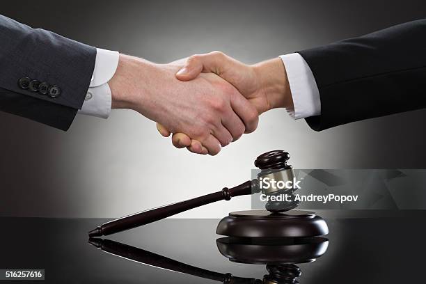 Businessman Shaking Hands In Front Of Mallet Stock Photo - Download Image Now - Lawyer, Auction, Adult