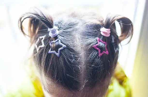 Little girl head with hairclips and tails