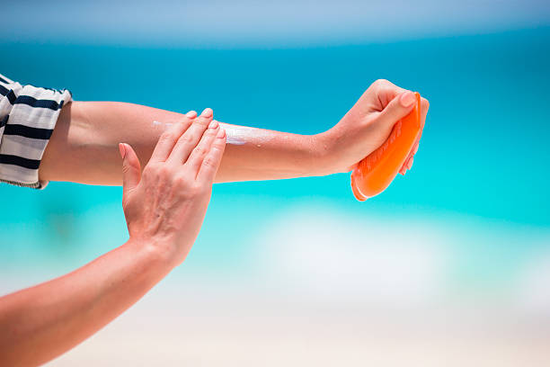istock girls apply hands sunscreen bottle background turquoise water 516260338