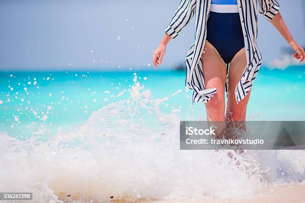 Womans Feet On The White Sand Beach In Shallow Water Stock Photo - Download Image Now