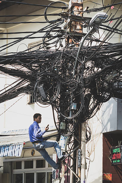 ножницы устраняя беспорядочным кабелей по телефону мачта - power line telephone line editorial asia стоковые фото и изображения