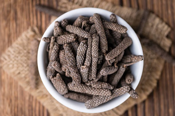 Dried Long Pepper Dried Long Pepper (selective focus) on vintage wooden background capsicum annuum longum stock pictures, royalty-free photos & images