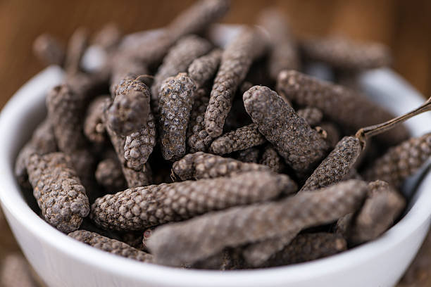 Heap of long Pepper Heap of long Pepper (selective focus) on wooden background (close-up shot) capsicum annuum longum stock pictures, royalty-free photos & images