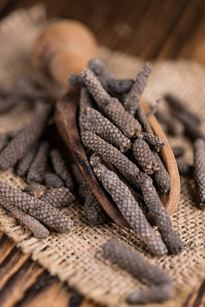 Long Pepper Long Pepper (dried) on an old wooden table (selective focus) capsicum annuum longum stock pictures, royalty-free photos & images
