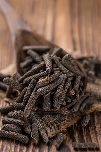 Heap of long Pepper Heap of long Pepper (selective focus) on wooden background (close-up shot) capsicum annuum longum stock pictures, royalty-free photos & images