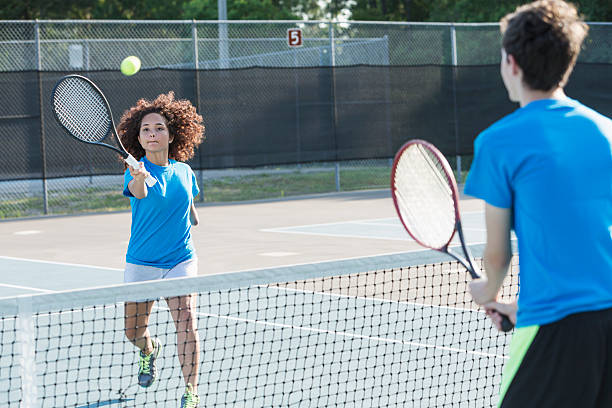 Physically challenged teenage girl playing tennis Physically challenged teenage girl playing tennis.  17 years, mixed race, African American. tennis teenager sport playing stock pictures, royalty-free photos & images