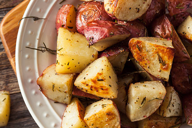 rôti aux herbes maison de pommes de terre rouge - red potato raw potato chopped vegetable photos et images de collection