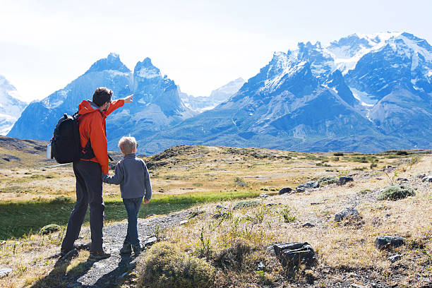 family hiking in patagonia family of two, father and son, enjoying hiking in torres del paine national park, patagonia, chile cuernos del paine stock pictures, royalty-free photos & images