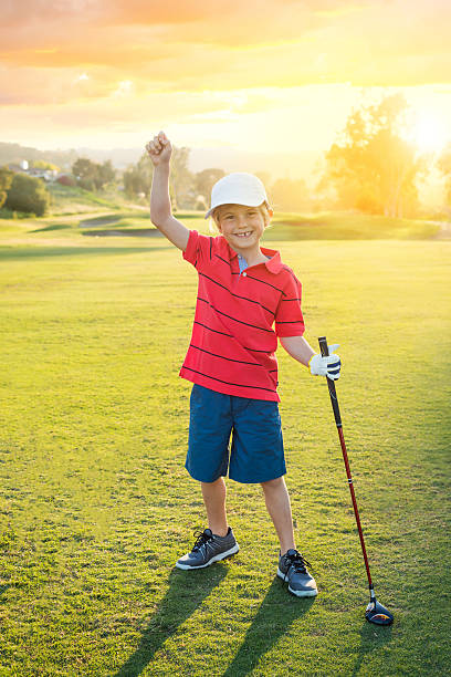 garoto golfista comemorando algo durante o pôr-do-sol - child swing swinging balance - fotografias e filmes do acervo