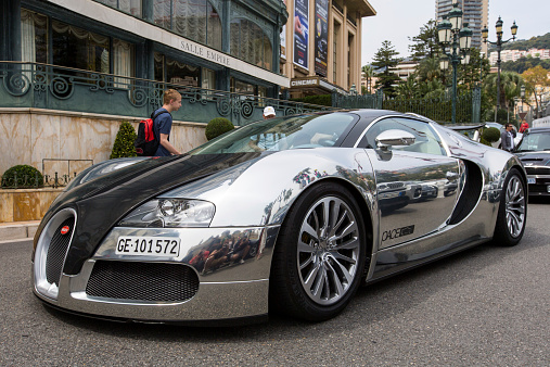 Monte Carlo, Monaco - April 18, 2014: Black/ Chrome Bugatti Veyron cruising around Monte Carlo Casino. Parked cars and people are reflected in the highly reflective bodywork. It is one of the the most expensive and fastest road-legal cars in the world.