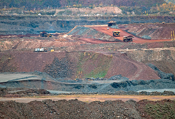Trucks loaded with iron ore drive to smelter at iron ore surface mine in Mesabi Iron Range of northern Minnesota