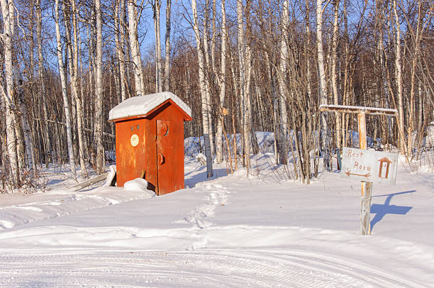 istock Alaska Remote Outhouse in Snow with Restroom Sign 516286536