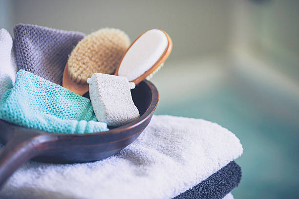 Stack of freshly laundered towels with wooden bowl and accessories