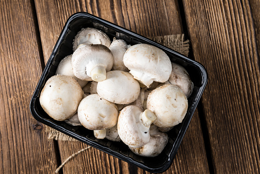 Portion of fresh white Mushrooms (selective focus) on wooden background
