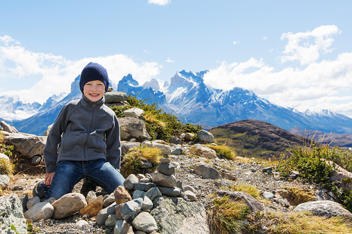 kid resting at mirador condor and enjoying hiking in torres del paine national park, patagonia, chile