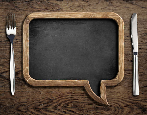 chalkboard with fork and knife on wooden dinning table