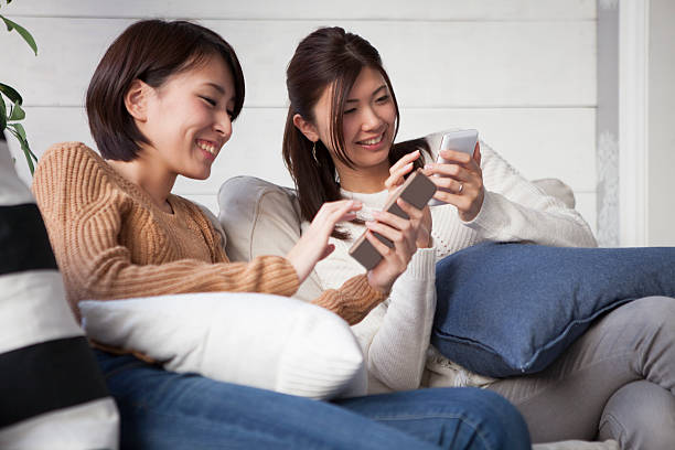 женщина отдыха и глядя на смартфон - sofa music teenager friendship стоковые фото и изображения
