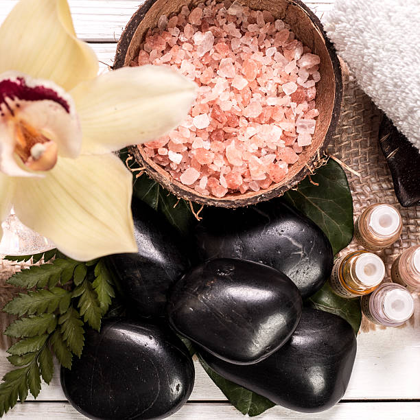 concept de spa en pierres, des fleurs, des huiles essentielles et aux sels minéraux - alternative therapy aromatherapy spa treatment candle photos et images de collection