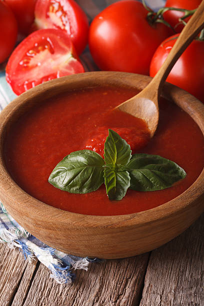 istock red tomato sauce with basil in wooden bowl closeup. vertical 516295426