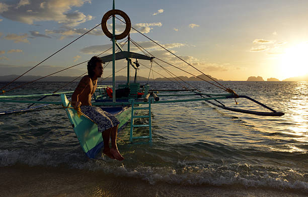 philippino con su tradicional de banca remar embarcaciones en filipinas - outrigger philippines mindanao palawan fotografías e imágenes de stock