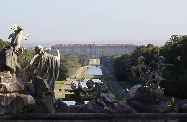 Caserta Palace Royal Garden. Caserta, Italy, August 14, 2014: Caserta Palace Royal Garden. Inspired by the park of Versailles, it is 3 kilometer long. In the foreground, angels'marble sculptures palace stock pictures, royalty-free photos & images