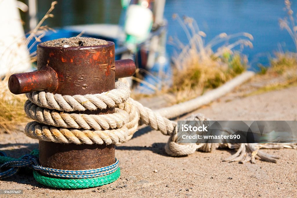 Closeup of boat cleat on a dock bollard with a rope tied to a pier Activity Stock Photo