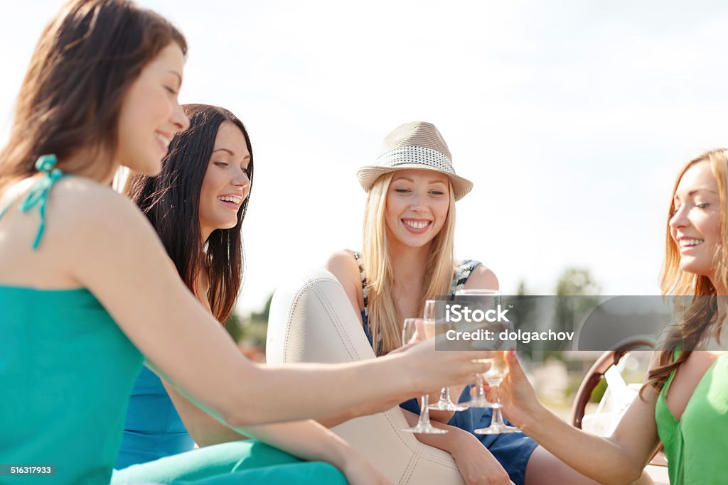 smiling girls with champagne glasses summer holidays, vacation and celebration concept - smiling girls with champagne glasses Adult Stock Photo