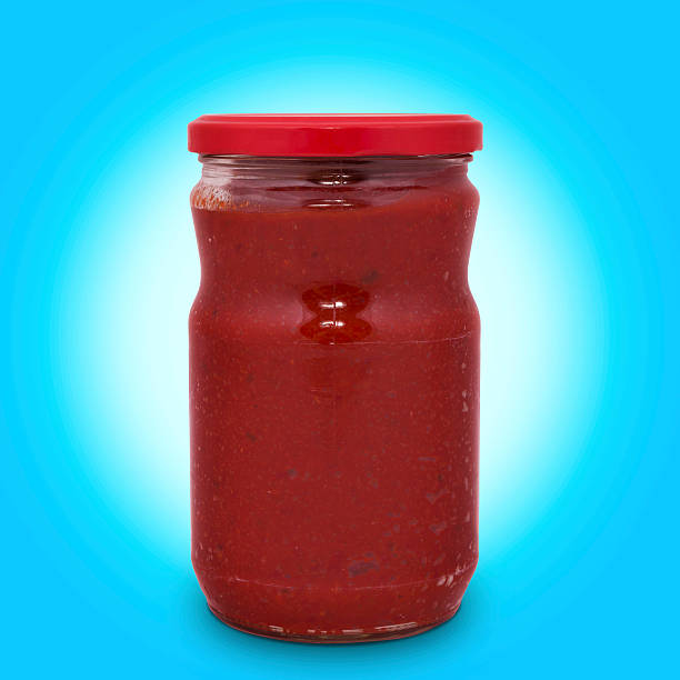 jar tomato paste isolated on blue background with path stock photo