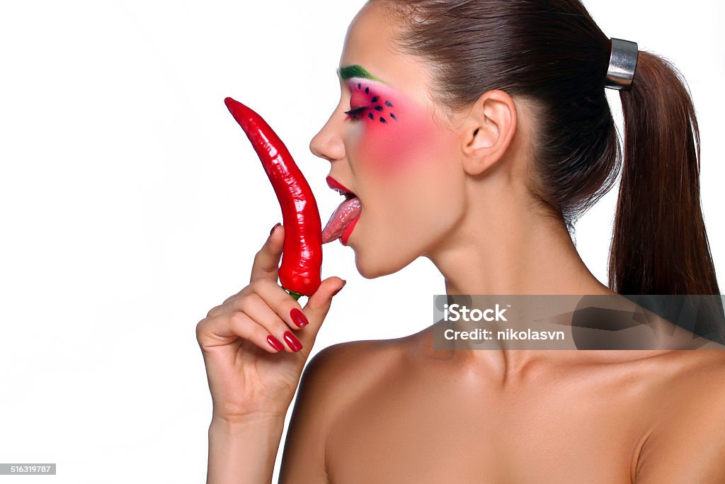 Girl posing with pepper Beautiful caucasian topless woman with chili pepper in mouth. Isolated on white. Adult Stock Photo